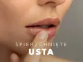 Delikatny dotyk palca na spierzchniętych ustach, szukając ulgi.