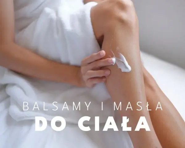 Kobieta w białym ręczniku nakłada na nogi bogate masło do ciała, zapewniając im nawilżenie i gładkość.